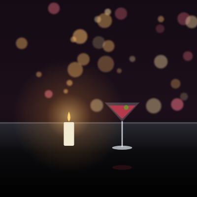 A candle and a glass on a terrace table at night
